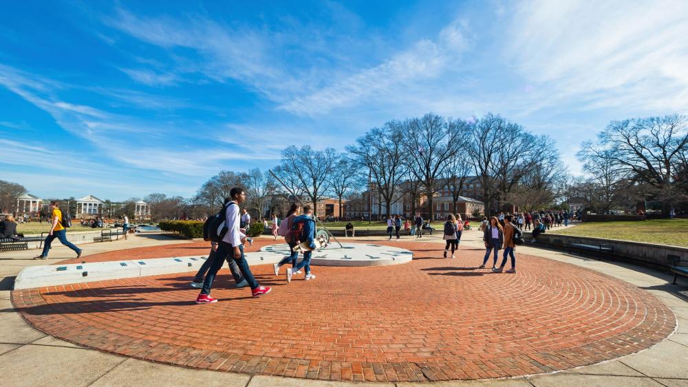 A view of the Sundial on the Mall with student activity on an unseasonably warm winter day.
